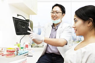 bigstock-Asian-Dentist-With-X-ray-And-P-36079342